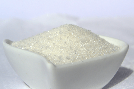 Açúcar cristal branco acondicionado em uma vasilha, com cristais de açúcar visíveis.