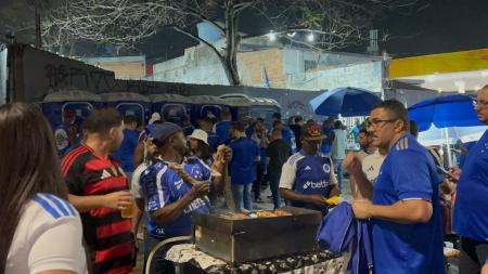 Gabriel Teixeira, flamenguista, compra um espetinho com um vendedor cruzeirense • Lucas Barbosa/Itatiaia