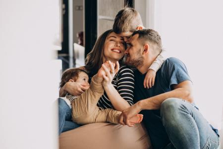 Mulher, homem e duas crianças se abraçam.
