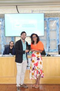 Professora Monique da Silva Ferreira recebendo a Comenda do Mérito Educacional no plenário da Câmara Municipal de Varginha.