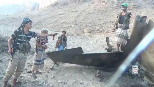 Membros do grupo Houthis posam com destroços de jato F-15 saudita derrubado em 16 de setembro de 2026