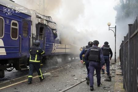 Bombeiros combatendo um incêndio em um vagão de trem danificado por um ataque de drone perto da fronteira com a Polônia