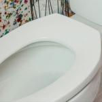 Para que serve a abertura frontal em formato de U nos vasos sanitários de banheiros públicos?