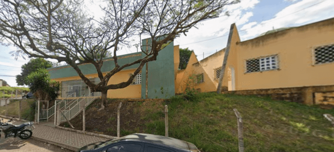 Profissional de saúde aplicando vacina no braço de uma pessoa idosa em sala de atendimento.