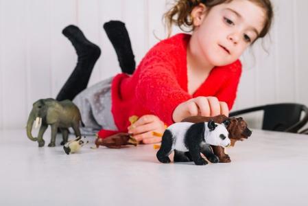 crianca brincando com miniaturas de animais