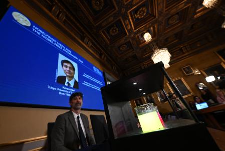 Recipientes com líquidos luminescentes ilustram as pesquisas dos vencedores do Nobel de Química de 2026, em Estocolmo, na Suécia. • Jonathan Nackstrand/AFP
