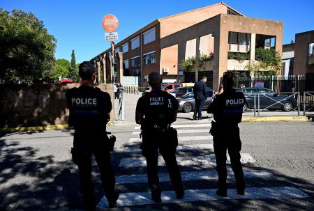 Policiais municipais franceses patrulham a área externa da escola de ensino fundamental Joseph-Lakanal após um diretor ter sido baleado e ferido por um rifle de caça e um adolescente ter sido preso em Aubagne, no sul da França, em 12 de outubro de 2026.