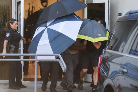 Flávio Bolsonaro e família se escondem com guarda-chuvas em desembarque nos EUA