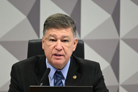 Senador Carlos Viana -de terno preto, blusa e gravata azul - fala ao microfone em bancada do Congresso Nacional