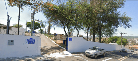 Entrada do Cemitério Municipal de Varginha com flores ornamentais e portões abertos para recepção de visitantes.