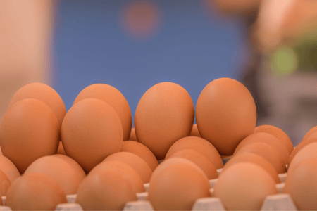 Ovos brancos e marrons acomodados em uma caixa de ovos.
