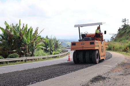 Equipe de manutenção viária realizando obras de reparo do pavimento em trecho de rodovia.