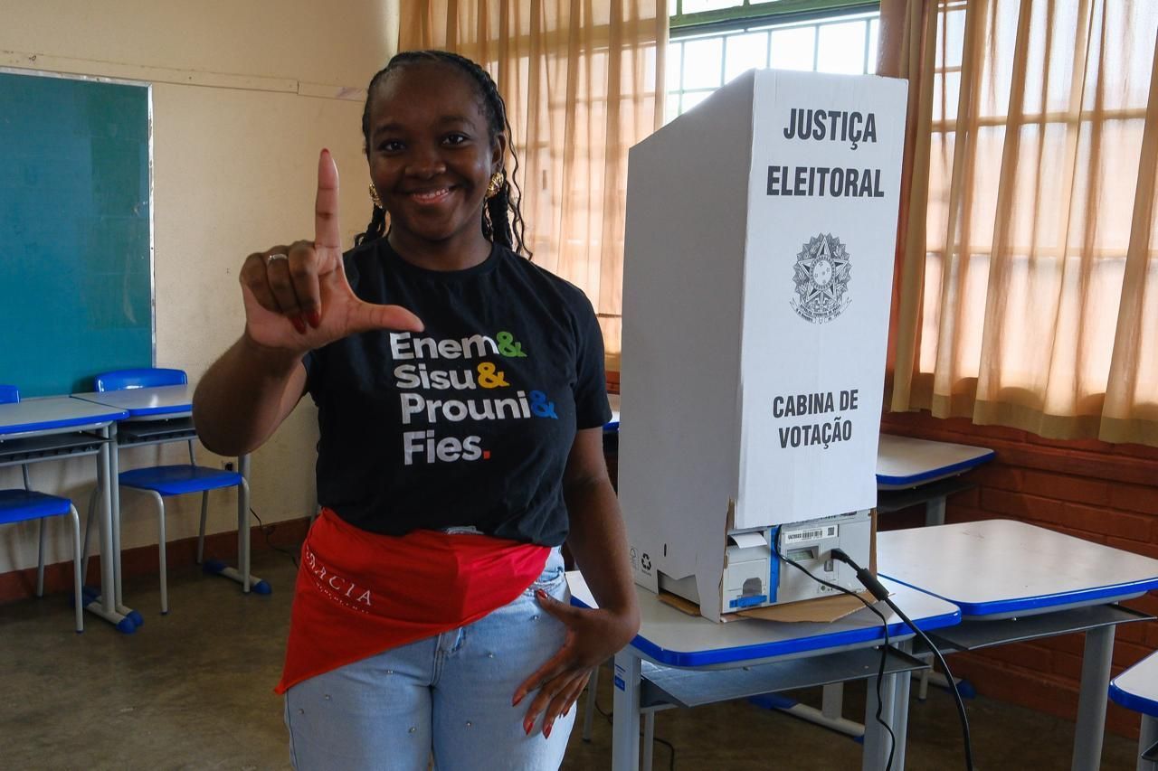 Eleições 2026: Ana Elisa, deputada federal eleita, vota com bandana vermelha escrita ‘Democracia’