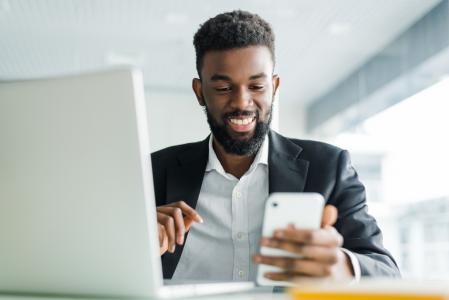 Homem sorri enquanto é atendido pelo seu banco de forma personalizada pelo celular.