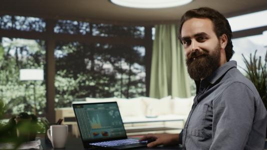 Homem sorri enquanto usa ferramentas de inteligência artificial para investir.
