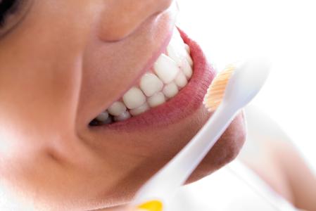 Retrato em close-up de uma linda jovem limpando os dentes