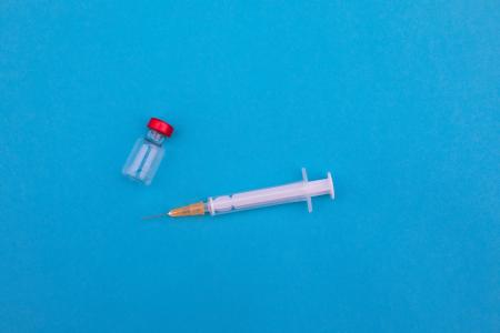 Medicamento injetável e ampola em fundo azul