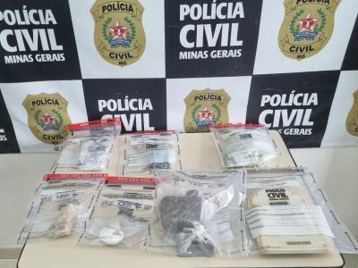 Materiais e invólucros de entorpecentes apreendidos sobre uma mesa na delegacia da Polícia Civil.
