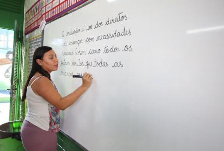 Professora de escola brasileira escreve frase em quadro branco