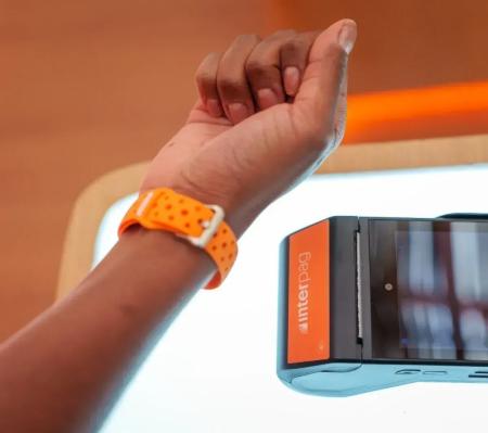 Pessoa usa wearable do Inter para fazer pagamento por aproximação.